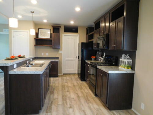 A kitchen with dark wood cabinets and granite counter tops.