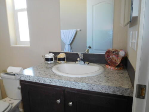 A bathroom with granite counter tops and a toilet.