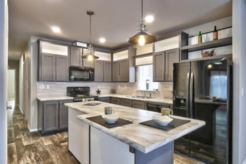 A kitchen with gray cabinets and stainless steel appliances.