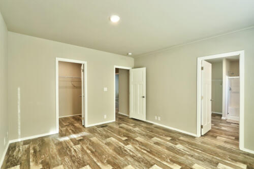 An empty room with hardwood floors and a closet.