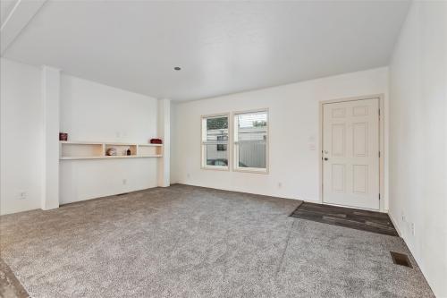 An empty room with gray carpet and white walls.