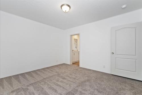 An empty room with carpet and white walls.