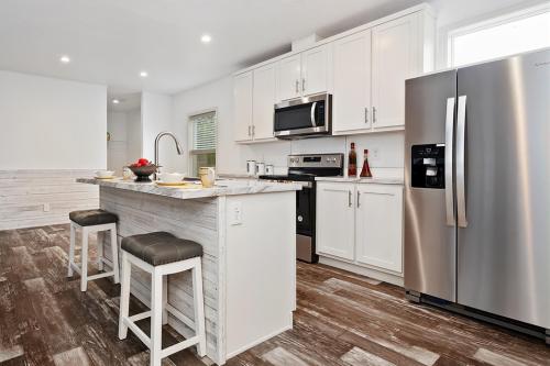 A white kitchen with wood floors and stainless steel appliances.