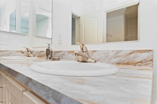 A bathroom with marble counter tops and sinks.