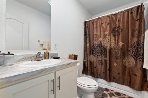 A bathroom with a brown shower curtain.