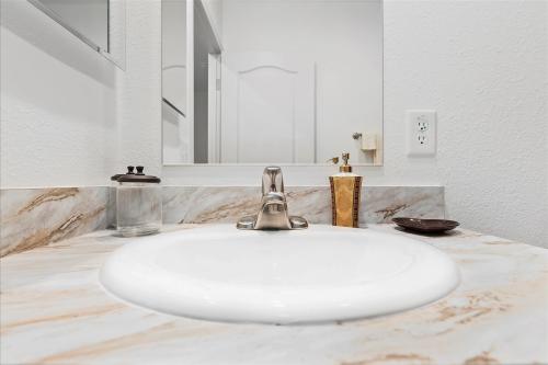 A bathroom with marble counter tops and a sink.