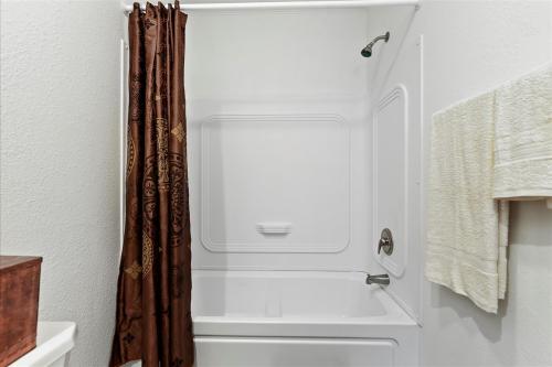 A bathroom with a brown shower curtain and toilet.