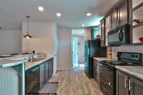 A kitchen with stainless steel appliances and hardwood floors.