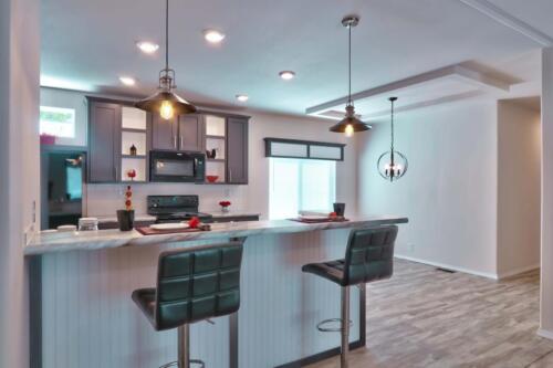 A kitchen with stools and a bar area.