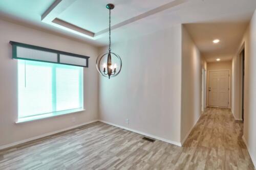 An empty hallway with wood floors and a light fixture.