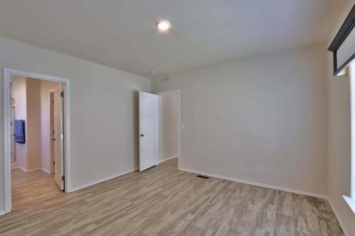 An empty room with wood floors and a door.